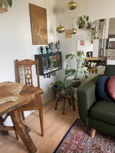 uma sala de estar com uma mesa e um sofá verde em Lake view em Aarhus