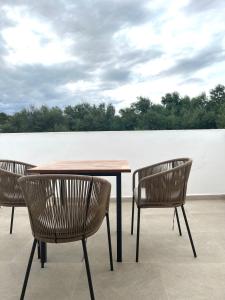 een tafel en drie stoelen rond een tafel bij Serena Sol in Cala Serena
