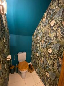 a bathroom with a toilet with a floral wallpaper at La Maison de Mel in Bois le Duc