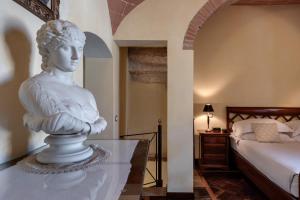 a statue sitting on a table in a bedroom at Castello Delle Serre in Rapolano Terme +51 photos