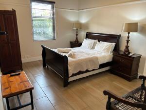 a bedroom with a bed with white sheets and a window at The Solomon Guest House in Kimberley