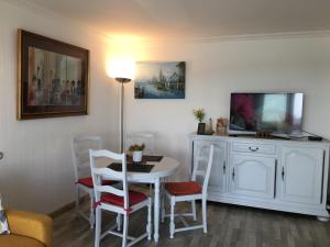 - un salon avec une table, des chaises et une télévision dans l'établissement Vue panoramique PORT et OCEAN, à Saint-Gilles-Croix-de-Vie