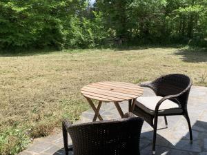 duas cadeiras e uma mesa de madeira num campo em Beautiful little house renovated in nature 