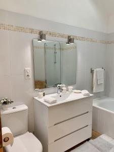 een badkamer met een wastafel, een toilet en een spiegel bij Beautiful little house renovated in nature 