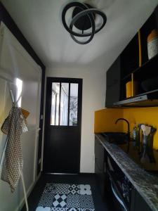 een keuken met een zwarte deur en een zwart-witte vloer bij Tropical in Mios