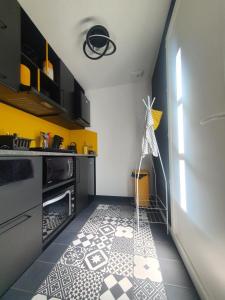 een keuken met een zwart-witte tegelvloer bij Tropical in Mios
