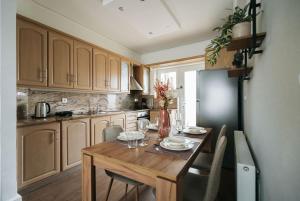 a kitchen with a wooden table with chairs around it at Luxury Port View in Lávrion