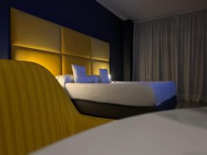 una habitación de hotel con 2 camas y una silla en B&B Baciami Ancora, en Bari