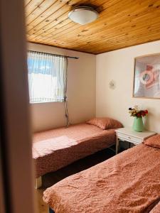 a bedroom with two beds and a wooden ceiling at 5 minute walk to Lego house - private studio apartment with Garden in Billund