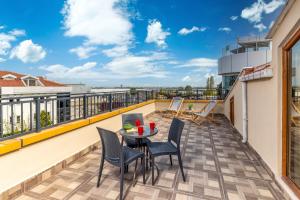 eine Terrasse mit einem Tisch und Stühlen auf dem Balkon in der Unterkunft Baymari Suites Design Florya in Istanbul