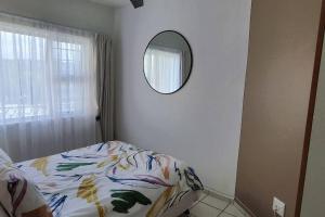 a bedroom with a bed and a mirror on the wall at Breathtaking View of the Blues in Margate