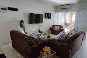uma sala de estar com dois sofás de couro e uma televisão em Breathtaking View of the Blues em Margate
