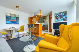 a living room with a yellow couch and a tv at Apartment Bruno in Split