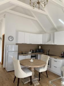 kuchnia z drewnianym stołem i białymi szafkami w obiekcie Beautiful little house renovated in nature 