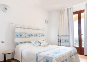 een witte slaapkamer met een bed en een raam bij La pavoncella pula in Pula