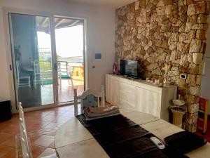 ein Wohnzimmer mit einer Steinmauer und einem TV in der Unterkunft Villa Chia’ in Santa Cesarea Terme