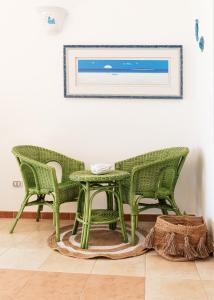 twee groene stoelen en een tafel in een kamer bij La pavoncella pula in Pula