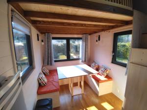 a small room with a table and chairs in a tiny house at Camping Les Granges Bas - Mobilhomes - Tiny House in Gérardmer