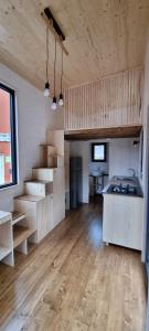- une cuisine avec du parquet et un escalier dans une chambre dans l'établissement Camping Les Granges Bas - Mobilhomes - Tiny House, à Gérardmer