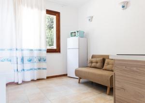 een woonkamer met een stoel en een koelkast bij La pavoncella pula in Pula