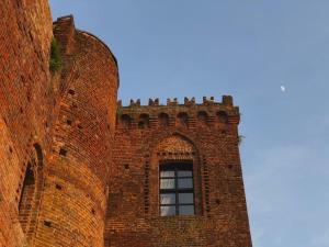un edificio de ladrillo alto con una ventana en él en Rocca di Arignano, en Arignano