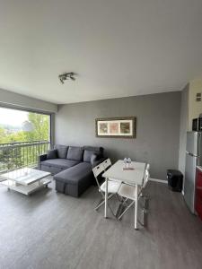 a living room with a couch and a table at Appartement à 100m de la plage in Villers-sur-Mer