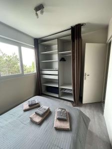 a bedroom with two towels on a bed with an open refrigerator at Appartement à 100m de la plage in Villers-sur-Mer