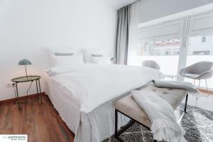 Un dormitorio blanco con una cama grande y una ventana en Aasee Apartment in top Lage 80m² mit 2 Schlafzimmern en Münster