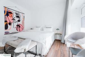 Un dormitorio con una cama blanca y una pintura en la pared en Aasee Apartment in top Lage 80m² mit 2 Schlafzimmern en Münster