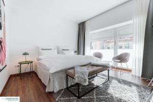 a white bedroom with a large bed and a window at Aasee Apartment in top Lage 80m² mit 2 Schlafzimmern in Münster