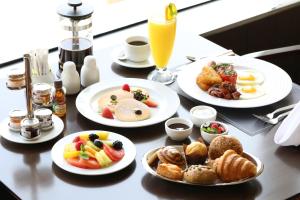 a table with plates of breakfast food on it at Four Points By Sheraton Kuwait in Kuwait