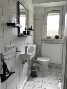 a white bathroom with a sink and a toilet at SANO - bei Joseph in Hagen- modernes Ambiente - Home office - Highspeed Internet - Waschmaschine in Hagen