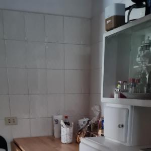 a kitchen with a white tiled wall and a tv at Robta's Dream Home in Rome