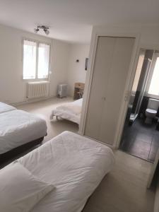 1 dormitorio con 2 camas y puerta corredera de cristal en A l'Orée de la Forêt en Campénéac