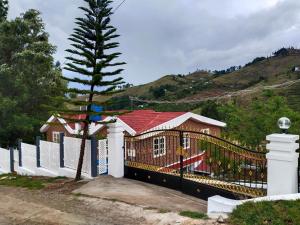 une maison avec une clôture et un arbre dans l'établissement INN THE MOUNTAIN'S, à Kodaikānāl