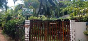 ein Tor vor einem Haus mit Palmen in der Unterkunft Pearl Bungalow Trincomalee in Trincomalee