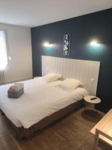 1 dormitorio con 1 cama blanca grande y pared negra en A l'Orée de la Forêt en Campénéac