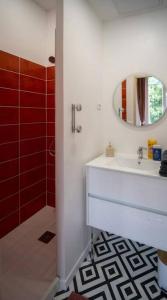 ein Badezimmer mit einem weißen Waschbecken und einem Spiegel in der Unterkunft L’appartement Le Mer’Ville in Saint-Nazaire
