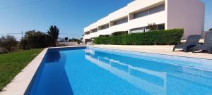 a swimming pool in front of a building at Villas Rocha in Albufeira