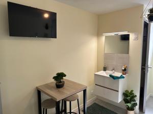 a bathroom with a sink and a table and a mirror at Studio de Célestine in Vernon