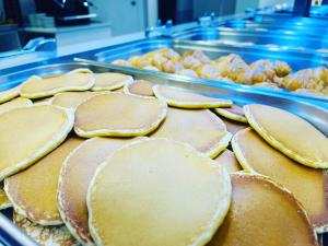 a pile of pancakes on a tray in a cafeteria at Hotel Susuqui in Sanxenxo