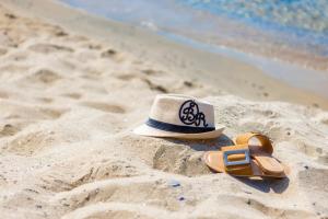 un sombrero y un par de sandalias en la playa en Onyx Beach Residence - Free Parking & Beach Access en Sveti Vlas
