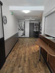 an empty room with a wooden floor and a piano at A l'Orée de la Forêt in Campénéac