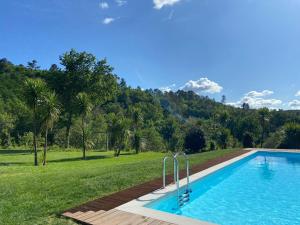 - une piscine avec une pelouse et des arbres dans l'établissement Devagar & Devagarinho, à Fafe