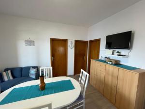 a living room with a table and a blue couch at Apartman Emilija in Vinišće
