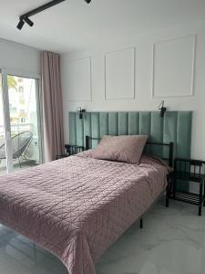 1 dormitorio con 1 cama grande y cabecero verde en Marbella Playa Real with sea view, en Marbella