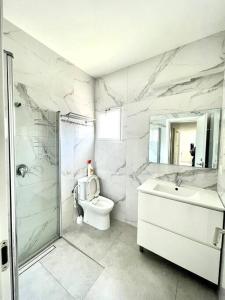 een badkamer met een toilet, een wastafel en een douche bij SVW Apartment on the Beach in Netanya