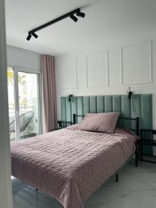 1 dormitorio con 1 cama con cabecero verde en Marbella Playa Real with sea view, en Marbella