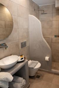 a bathroom with a sink and a toilet and a mirror at Perissa Bay in Perissa