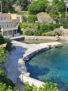 a body of water with a building and trees at Casa Bella in Karlobag